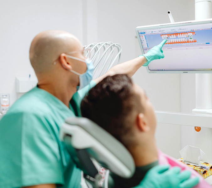 Dental Professional Demonstrating Tooth Anatomy and Examination Results on a Digital Monitor