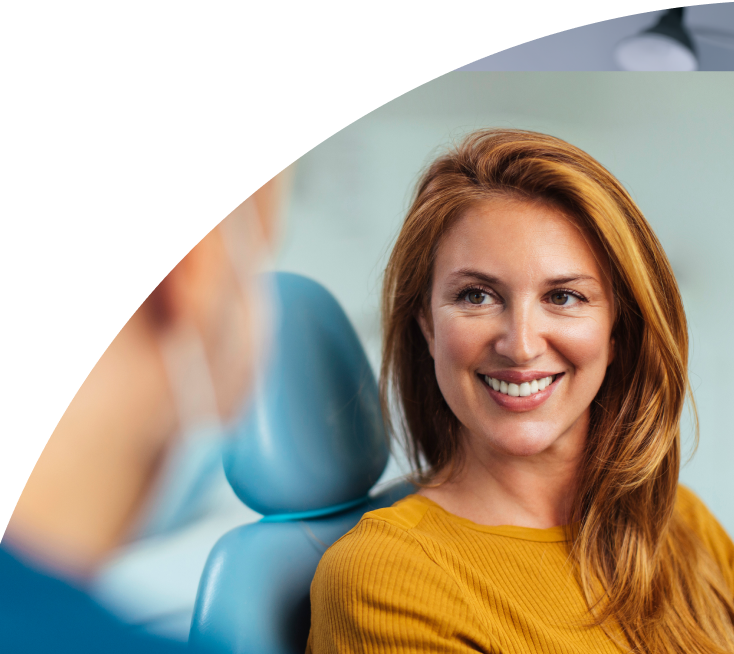 Female Patient with a Healthy-Looking Smile Relaxing in a Dental Treatment Chair