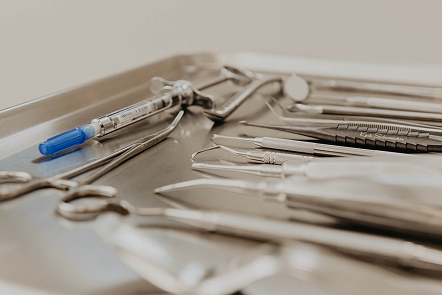 Sterile tray of dental anesthesia syringes and surgical instruments prepared for oral surgery procedures
